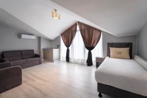 1 dormitorio con 1 cama y 1 sofá en Rubby Hotel Kadıköy en Estambul
