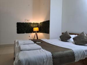 een slaapkamer met 2 bedden en kussens erop bij V2 in Guwahati