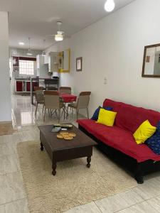 salon z czerwoną kanapą i stołem w obiekcie Casa com piscina incrível. w mieście Serra Talhada