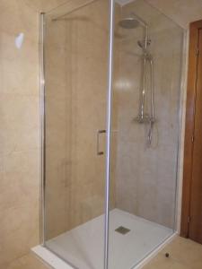 a shower with a glass door in a bathroom at Cantinho Santiago in Belmonte