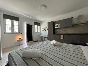 a large bedroom with a large bed and a kitchen at Corridoni33 - Immobili e Soluzioni Rent in Bergamo