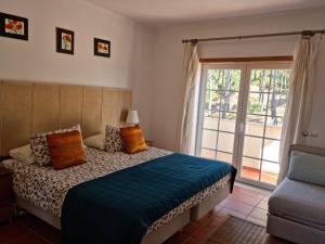 a bedroom with a bed and a sliding glass door at Praia D'El Rey - Townhouse Dom Duarte in Amoreira +18 photos