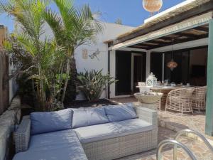 patio con divano, tavolo e palme di Casa Rosalía a Corralejo