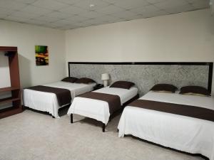 a room with three beds in a room at Hotel America - La Chorrera in La Chorrera