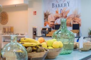 a counter with two glass bottles and bowls of fruit at Apartamentos Galeon Playa in Costa Teguise