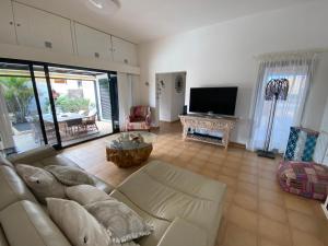 ein Wohnzimmer mit einem Sofa und einem TV in der Unterkunft Casa Rosalía in Corralejo