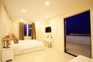 a bedroom with a white bed and a large window at Tuyet Son Hotel (TS Ocean Hotel) in Da Nang