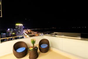 a balcony with three chairs and a view of the city at Tuyet Son Hotel (TS Ocean Hotel) in Da Nang