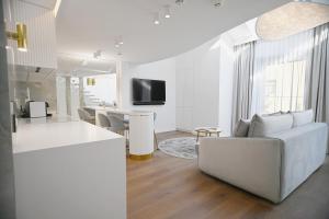 a white living room with a couch and a table at Prestige Sopot Residence by 3City Rentals in Sopot