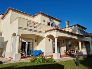 a large white house with a patio at Praia D'El Rey - Townhouse Dom Duarte in Amoreira