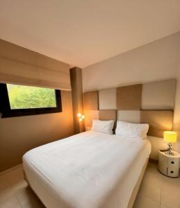 a bedroom with a large white bed with a window at Arthur Properties - Montfleury in Cannes +9 photos