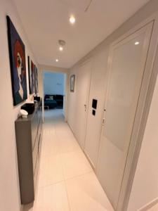 カンヌにあるArthur Properties - Montfleuryの白いドアとタイルフロアの廊下
