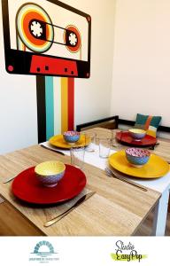 una mesa con platos y cuencos encima en Locations du Grand Pont - Appart hôtel Poitiers - Futuroscope, en Chasseneuil-du-Poitou