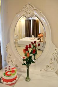 a table with a vase of flowers and a mirror at Tuyet Son Hotel (TS Ocean Hotel) in Da Nang