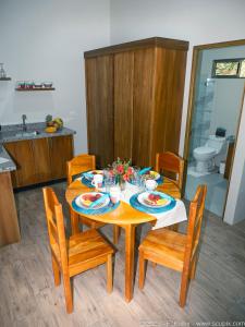 una mesa de comedor con sillas y una mesa con flores. en Luxury Apartments Nauyaca by Paradiselodge, en Platanillo