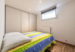 Schlafzimmer mit einem Bett und einem Fenster in der Unterkunft Locqui in Locquirec