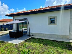 a white house with a patio with an umbrella at Maison 2/4 personnes in Josse