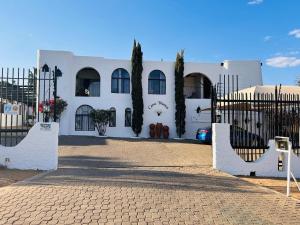 ein weißes Haus mit einem Tor davor in der Unterkunft Casa Blanca Boutique Hotel Pension in Windhoek