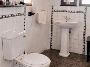Baño blanco con aseo y lavamanos en Casa Blanca Boutique Hotel Pension en Windhoek