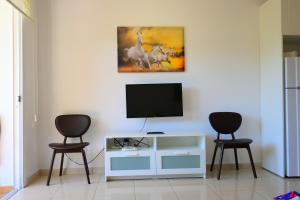 a living room with two chairs and a television at Отдыхайте с удовольствием in Paphos