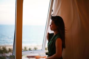 a woman is looking out of a window at Tuyet Son Hotel (TS Ocean Hotel) in Da Nang
