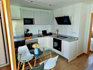 a kitchen with a glass table and white cabinets at Maison 2/4 personnes in Josse