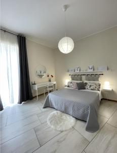 - une chambre blanche avec un grand lit et une table dans l'établissement Diverso Apartment, à Caiazzo