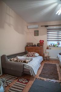 um pequeno quarto com uma cama e uma janela em Prenoćište Lelić em Valjevo