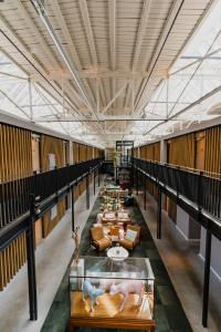 فندق دو هولين في أمستردام: ممر طويل مع طاولات وأرائك في مبنى