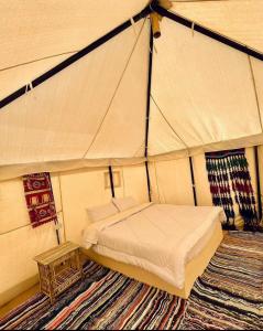 ein Schlafzimmer mit einem Bett in einem Zelt in der Unterkunft Tache By The Lake in Al-Fayyūm