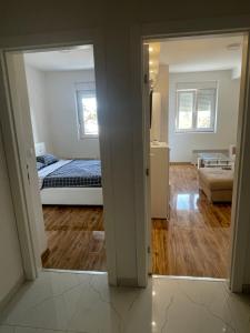 a view of a bedroom with a bed and a living room at Stan na dan Bratunac in Bratunac