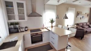 eine Küche und ein Wohnzimmer mit einem Sofa und einem TV in der Unterkunft Casa en Cortiñan in Bergondo + 7 Fotos