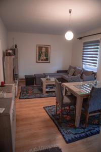 ein Wohnzimmer mit einem Tisch und einem Sofa in der Unterkunft Prenoćište Lelić in Valjevo