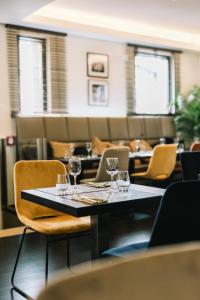 a dining room with a table with wine glasses on it at Hotel Mia Zia in Belvaux