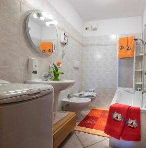 bagno con lavabo, servizi igienici e specchio di Appartamenti Baita Soliva a Oga