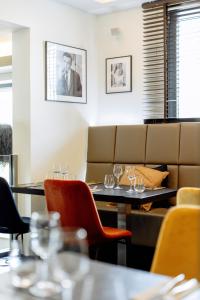 ein Restaurant mit Tischen und Stühlen und einer Couch in der Unterkunft Hotel Mia Zia in Belvaux