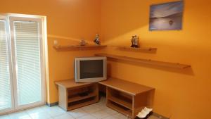 un soggiorno con TV e scaffali a parete di Apartment Ivanka a Pag