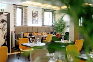 - une salle à manger avec des tables, des chaises et un canapé dans l'établissement Hotel Mia Zia, à Belvaux