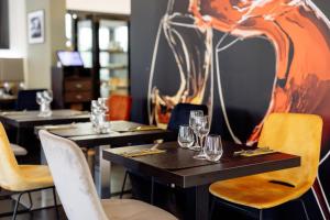 BelvauxにあるHotel Mia Ziaのテーブルと椅子(ガラス付)が備わるレストラン