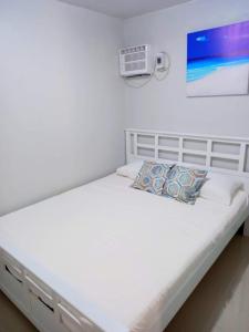 Sönmez Private Villa في Cavite: سرير أبيض في غرفة بيضاء مع
