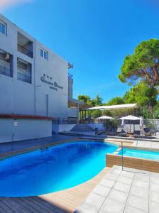 a swimming pool in front of a building at Golden Beach Hotel in Metamorfosi