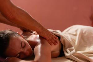 Una mujer recibiendo un masaje de un hombre en Hotel Dusseldorf, en Rímini