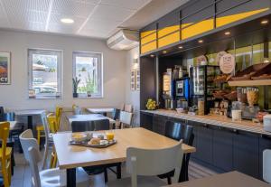 a restaurant with a table and chairs and a counter at B&B HOTEL Annecy in Argonay