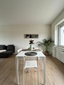 uma mesa branca e cadeiras numa sala de estar em Lumineux Apt 1BR Type Loft Proche Centre em Thionville