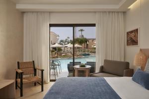 a hotel room with a bed and a view of a pool at Atlantica Aeneas Resort in Ayia Napa
