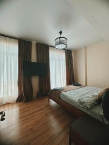 a bedroom with a bed and a large window at Prestigio Sea view apart in Batumi