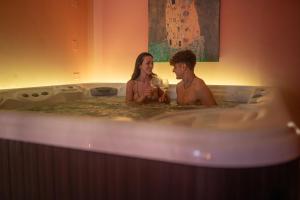 un hombre y una mujer sentados en una bañera en Hotel Dusseldorf, en Rímini