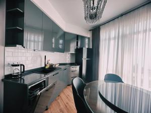 a kitchen with a glass table and black cabinets at Prestigio Sea view apart in Batumi