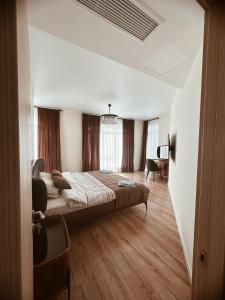 a bedroom with a large bed and a desk at Prestigio Sea view apart in Batumi