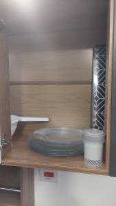 uma prateleira com pratos e tigelas num armário em Estúdios Jardim Emília em Sorocaba